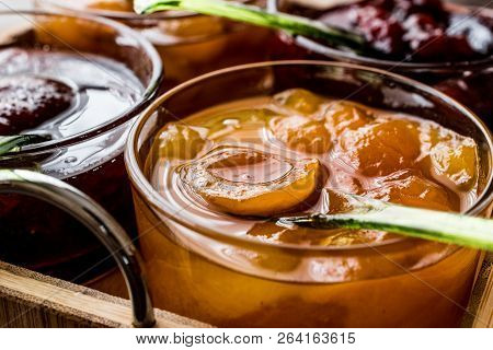 Apricot Jam In Glass Bowl With Spoon And Various Fruit Marmalades