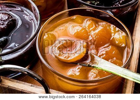 Apricot Jam In Glass Bowl With Spoon And Various Fruit Marmalades