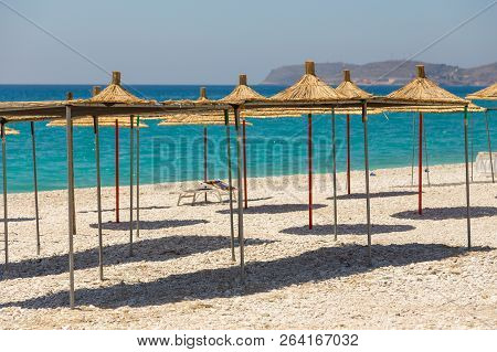 Umbrellas On The Borsh Beach In Albania. Stony Beach On The Adriatic Sea.