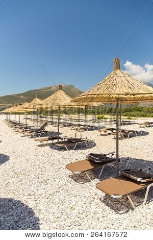 Umbrellas On The Borsh Beach In Albania. Stony Beach On The Adriatic Sea.