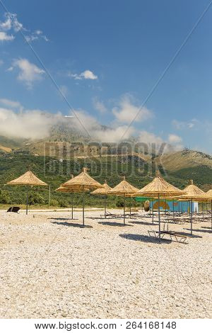 Umbrellas On The Borsh Beach In Albania. Stony Beach On The Adriatic Sea.