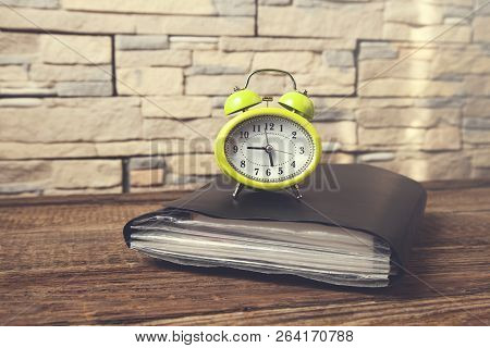 Vintage Clock On Notepad On Wooden Desk