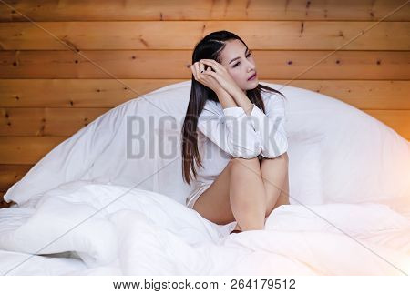 The Beautifu Laday Is Sitting On Bed,put Her Hand Touch Head,unhappy Feeling,headache From Tried And