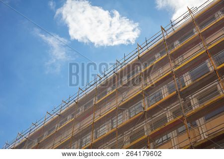 Under Construction. Building Construction With Scaffolding, Blue Sky Background