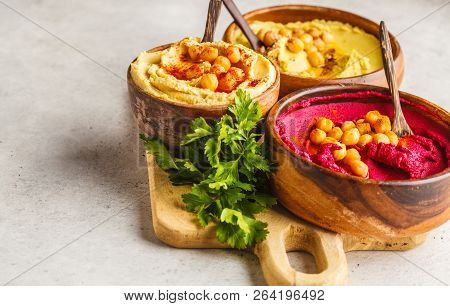 Different Hummus Bowls. Chickpea Hummus, Avocado Hummus And Beet Hummus. Plant Based Diet Food.