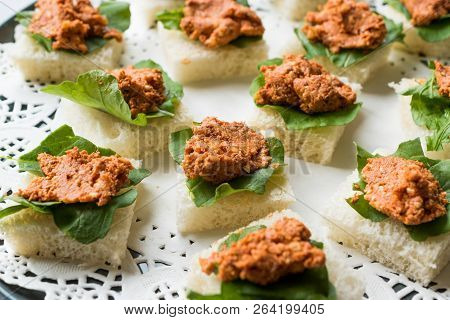 Canape With Muhammara, Adjika, Ajika Or Acuka On Small Square Breads With Round Plate.