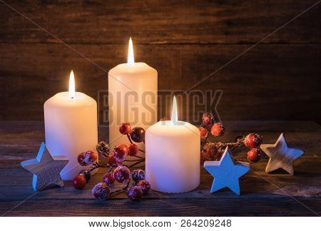 Christmas Star Shapes And Red Berries Decoration With Festive Burning Candles On Wood Background