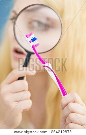 Beautiful Perfectionist Young Woman Checking Her Tooth Brush Through Manifying Loupe Glass. Hygiene,