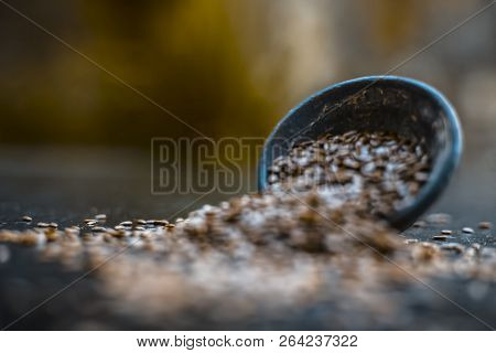 Close Up Of Ayurvedic Herb Alsi Or Adsi Or Flax Seed In A Black Colored Clay Bowl On Wooden Surface
