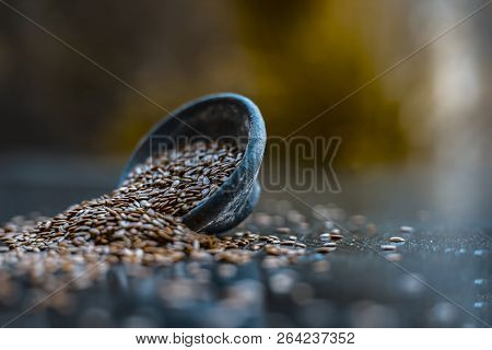 Close Up Of Ayurvedic Herb Alsi Or Adsi Or Flax Seed In A Black Colored Clay Bowl On Wooden Surface