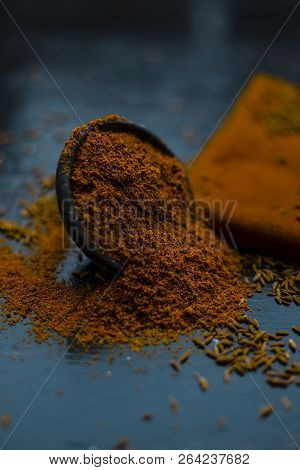 Close Up Of Powdered Cumin Or Zeera Or Jeera With Raw Cumin On Wooden Surface In A Clay Bowl On A Cl