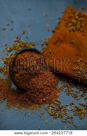 Close Up Of Powdered Cumin Or Zeera Or Jeera With Raw Cumin On Wooden Surface In A Clay Bowl On A Cl