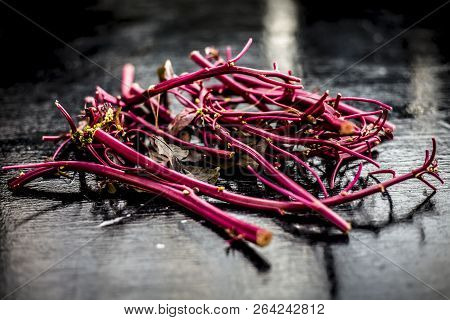 Close Up Of Raw Amaranth Leaves's Branches On Wooden Surface Without Its Leaves.