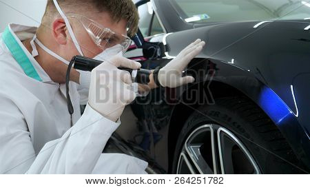 Professional Master After Polishing And Painting Cars, Checks The Flashlight Scratches, A Respirator