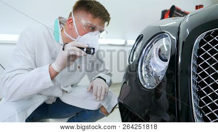Professional Master After Polishing And Painting Cars, Checks The Flashlight Scratches, A Respirator