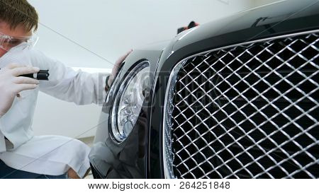 Professional Master After Polishing And Painting Cars, Checks The Flashlight Scratches, A Respirator