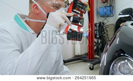 Professional Master After Polishing And Painting Cars, Checks The Flashlight Scratches, A Respirator