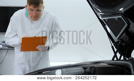 Professional Master After Polishing And Painting Cars, Checks The Flashlight Scratches, A Respirator