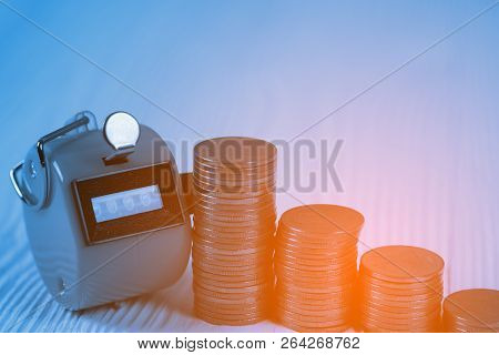 Tally Counter Or Counting Machine With 0000 Number, Step Of Coin Stack On White Wooden Table, Busine