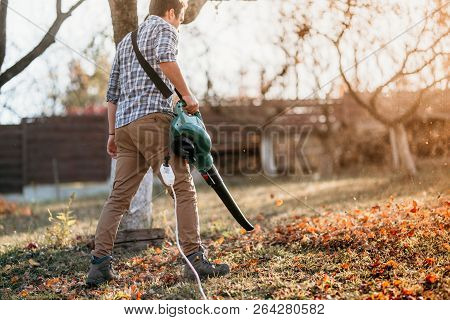 Home Gardening Industry - Male Using Leaf Blower During Sunset