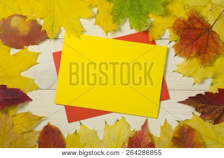 Frame Autumn Leaves With Yello Envelope On Wooden Background. Colorful Template For Design