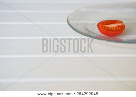 A Half Of Fresh Tomato Lies On A Transparent Plate On A White Background. Healthy Food. Template