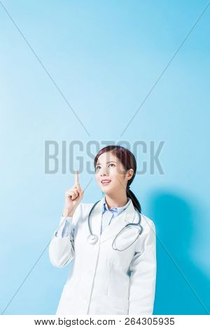 Woman Doctor Pointing Something And Look Somewhere On The Blue Background