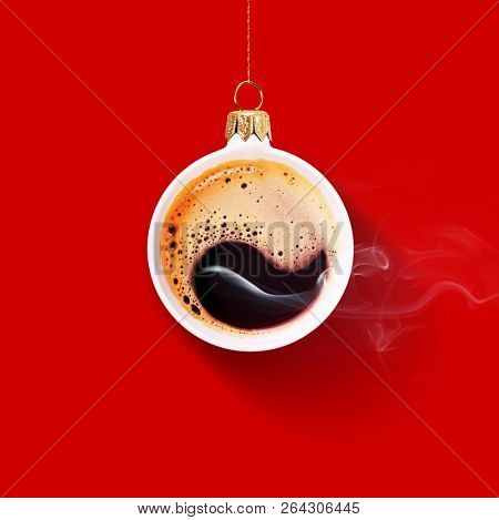 Christmas toy is made from a fragrant cup of coffee. Christmas toy. Holiday concept. Fragrant coffee on a red background for your advertising. Smoke from hot coffee.