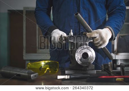 Man Worker Is Working With Iron Detail On Vise Grip On Blacksmith Table.