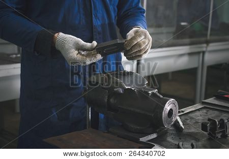Man Worker Is Working With Iron Detail On Vise Grip On Blacksmith Table.