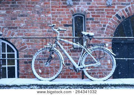 Winter Day In City. Snow Covered Bicycle Parked On Streen