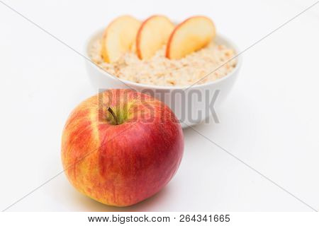 Oatmeal In White Bowl And Red Apple On White Background. Isolated On White. Healthy Food