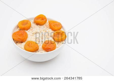 Oatmeal With Dried Apricots In White Bowl On White Bakcground. Isolated On White. Healthy Food