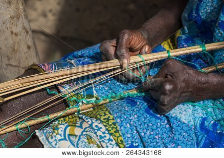 Detail Of The Hands Of An Old Woman Working In Front Of Her Hut At The Village Of Eticoga In The Isl