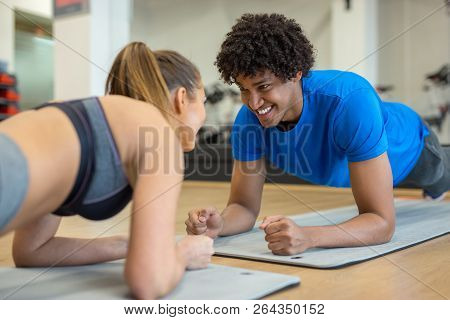 Handsome Young Couple Working Out At The Gym Smiling At Each Other