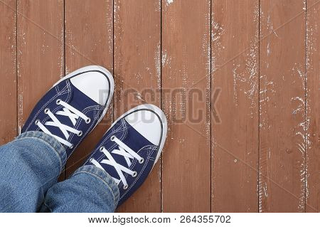 Clothes, Shoes And Accessories - Top View Closeup Legs Put In Gumshoes And Blue Jeans Top View On A 