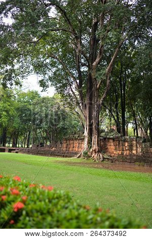 Tree Roots Grow Over Stone Castle In Meuang Sing Historical Park, Thailand.