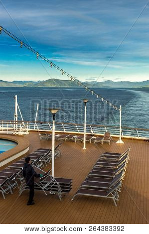 Inside Passage, Bc, Canada - September 13, 2018: Cruise Ship Worker Stacking Outdoor Loungers In The