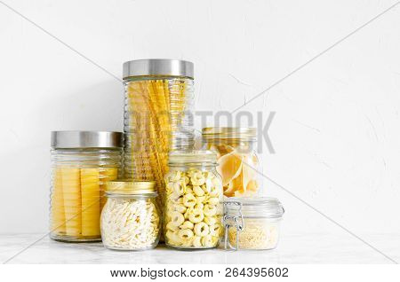 Variety Of Types And Shapes Of Italian Pasta In Glass Jars On White Background. Italian Cuisine Food
