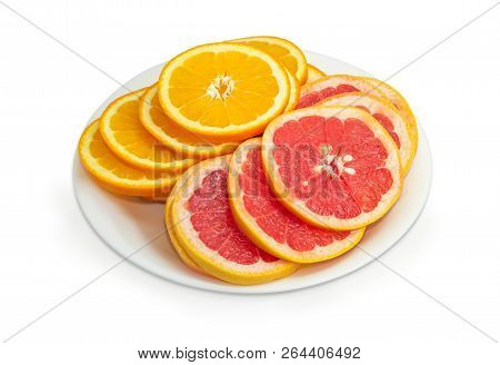 Pile Of The Round Slices Of The Ripe Oranges And Red Grapefruits With Their Peel On The White Dish O