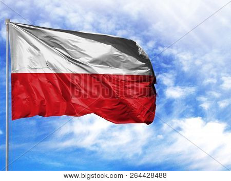 National Flag Of Poland On A Flagpole In Front Of Blue Sky