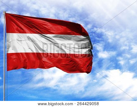 National Flag Of Austria On A Flagpole In Front Of Blue Sky