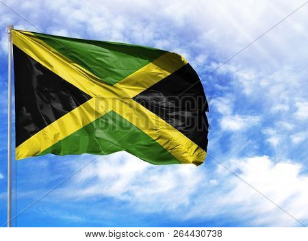 National Flag Of Jamaica On A Flagpole In Front Of Blue Sky