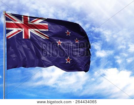 National Flag Of New Zealand On A Flagpole In Front Of Blue Sky