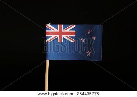 A Official Flag Of New Zealand On Wooden Stick On Black Background Created By Paper. New Zealand Bel
