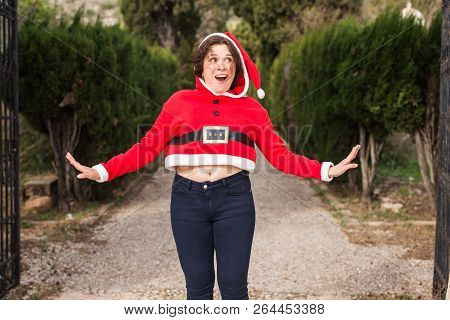 Christmas, Holidays, Humor And People Concept - Funny Happy Woman In Santa Suit Dancing Outdoors