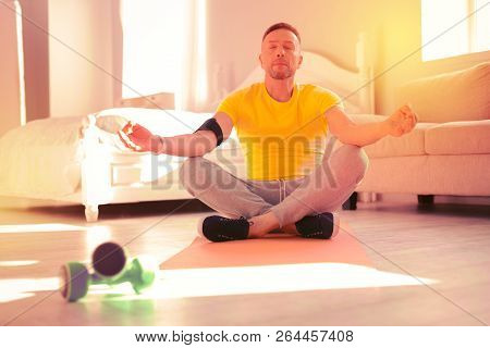 Relaxed Calm Man Meditating At Home On The Floor