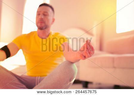 Calm High-spirited Man Doing Yoga On The Floor At Home
