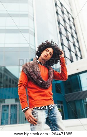 Young Fashionable Dressed Curly Black African American With Glasses Walks Through The Streets Agains