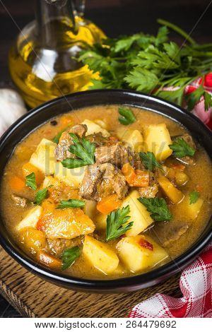 Goulash With Meat And Vegetables In Black Bowl. Beef Stew With Vegetables. European Cuisine.